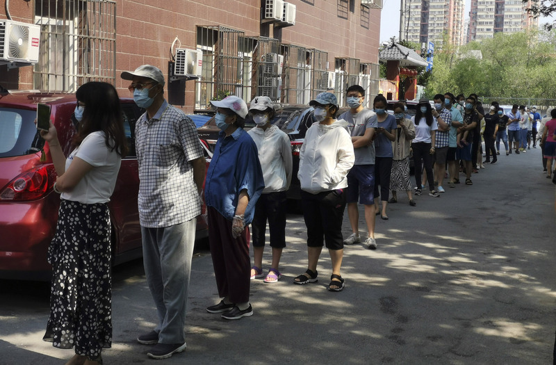 據官方通報，中國首都北京市11日爆發2019冠狀病毒疾病本土疫情迄今，累計確診已突破200來到205例。圖為19日，北京西城區一個實施封閉管理的社區，居民排隊接受核酸檢測。（中新社提供/中央社）