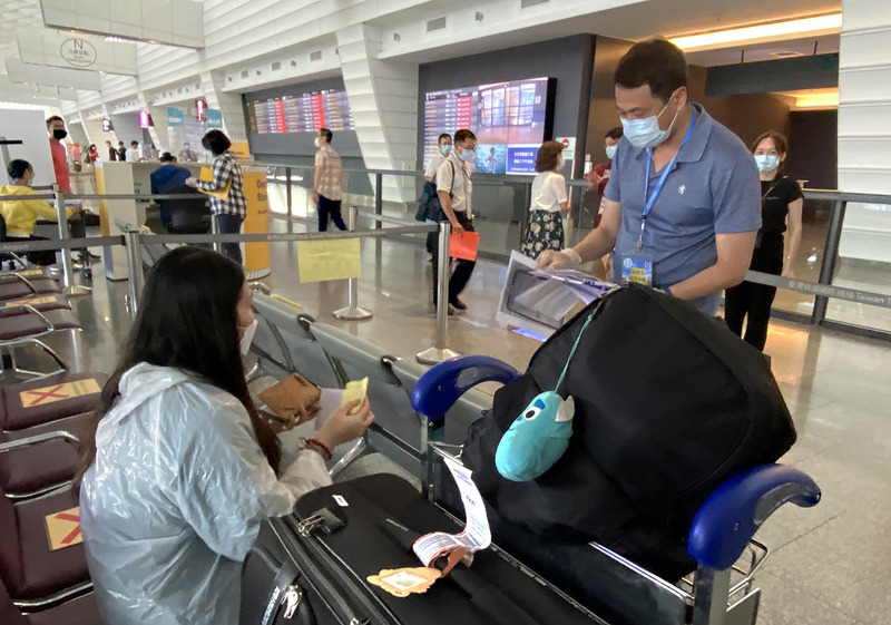 中央流行疫情指揮中心日前宣布優先開放11個低風險國家、地區應屆畢業生分批返台就學，26日下午首批境外生飛抵台灣，抵達入境大廳後，再依指示到教育部設置的櫃台報到，由學校輪值人員協助安排後續交通事宜。(圖:中央社)