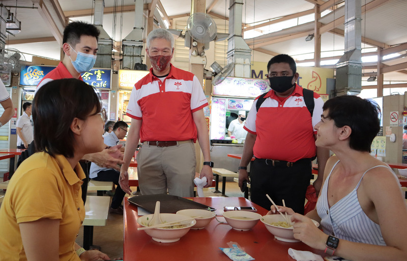 新加坡總理李顯龍胞弟李顯揚加入在野黨新加坡前進黨，李顯揚（右3戴紅色口罩）27日下午與新加坡前進黨參選人共同走訪荷蘭村一帶的美食中心。（圖：中央社）