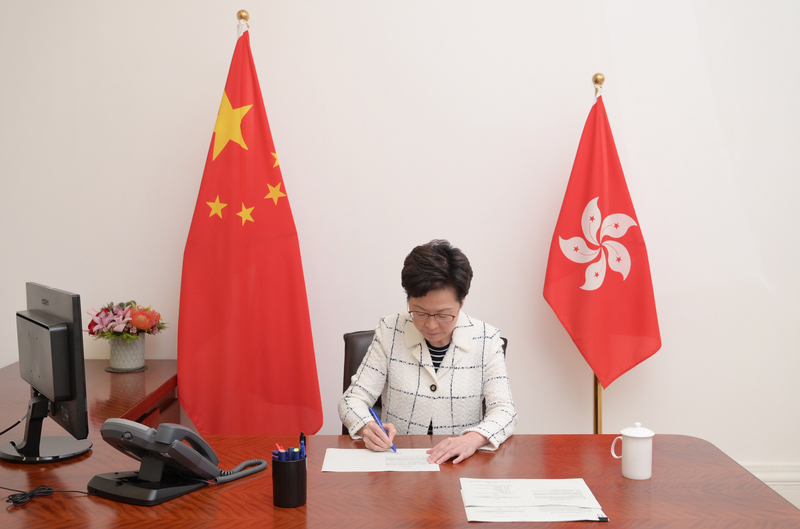 香港行政長官林鄭月娥1日在香港特別行政區成立23週年典禮後致詞時說，過去一年是她40年公務生涯中最嚴峻的考驗，但她感謝北京中央對其信任，相信香港可以否極泰來。圖為林鄭昨晚簽署生效「港區國安法」。（中通社提供）(資料照片/CNA)