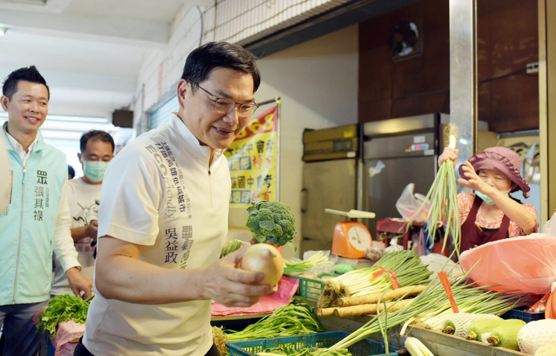 台灣民眾黨高雄市長補選參選人吳益政（前中）1日到苓雅區正義市場拜票，向民眾及攤商爭取支持。(圖:中央社)
