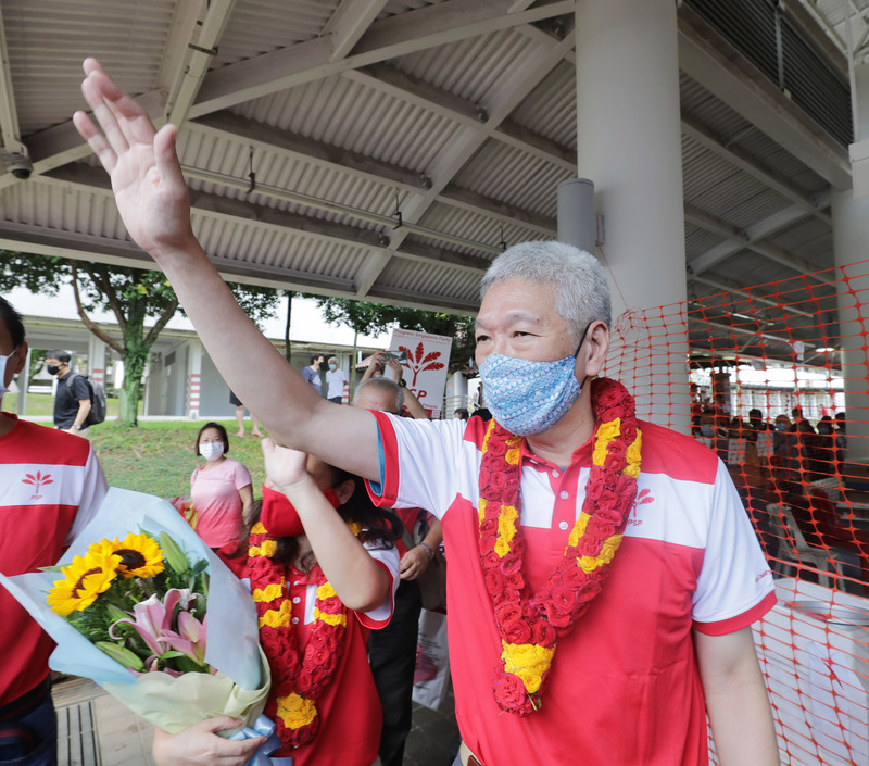 新加坡大選超級星期天，總理李顯龍胞弟李顯揚（右）5日陪同新加坡前進黨候選人走訪選區。(中央社)