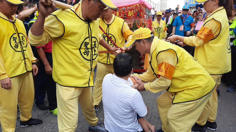 2020苗栗通霄拱天宮白沙屯媽祖回鑾，一名服飾業者抱著生病的孫子跪在神轎前，求媽祖保佑孫子能平安長大。（民眾提供）(圖：中央社 )