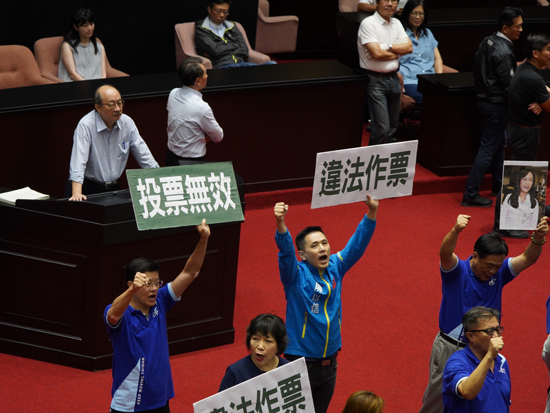 立法院17日將進行監察院人事同意權投票，國民黨立委在議場內舉看板指出，民進黨立委陳瑩不在現場卻有投票紀錄，因此將主張16日會議無效，應重新開審查會，再行使同意權。(圖：中央社)