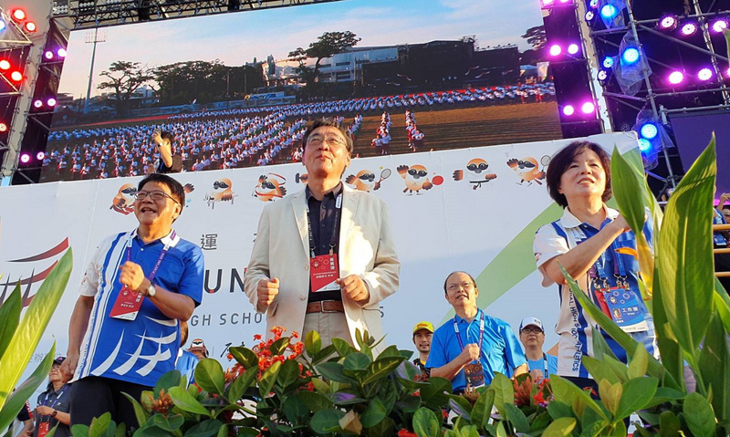 109年全國中等學校運動會18日在屏東縣立田徑場盛大舉行開幕典禮，屏東縣長潘孟安（左）及與會來賓一起和現場學生大跳全中運主題舞「驕仔舞」，而競技場上首日就有16項破大會紀錄。(中央社)