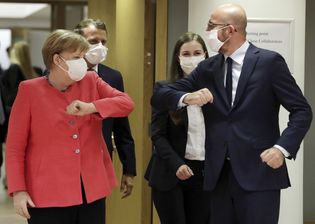 德國總理梅克爾(Angela Merkel)與歐洲理事會主席米歇爾(Charles Michel)戴口罩擊肘打招呼。 (AFP)