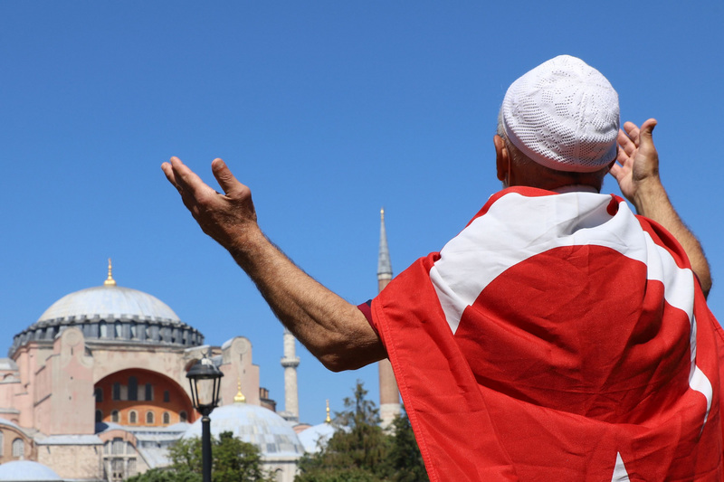 土耳其將擁有近1500年歷史的世界遺產聖索菲亞改成清真寺。圖為一名穆斯林身披土耳其國旗，在建築前方祈禱。(圖:中央社)