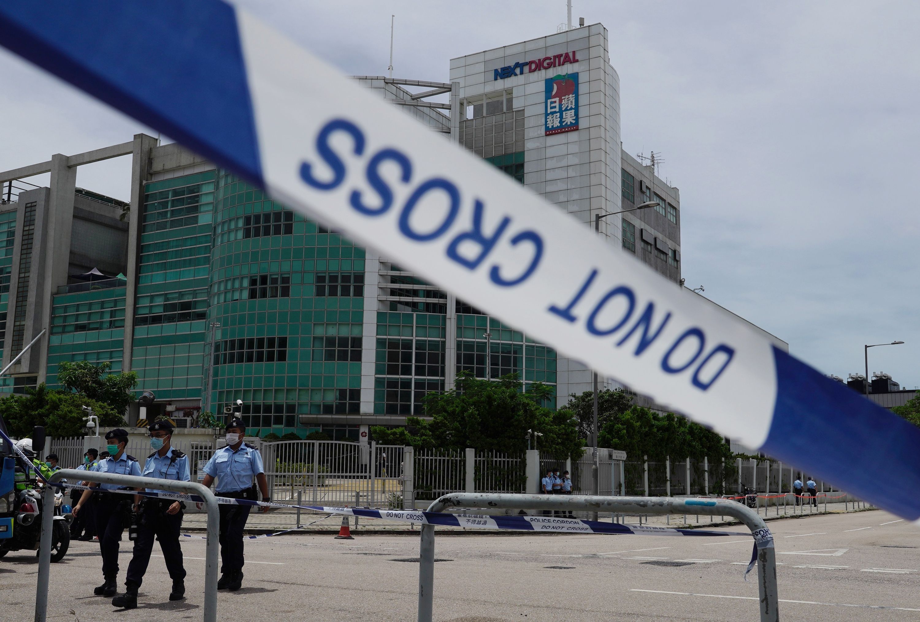 港區國安法生效後，多間香港傳媒機構被迫停運。圖為香港警方2020年8月10日派出大批員警進入蘋果日報位於將軍澳的大樓內搜證，並封鎖大樓周邊街道。(美聯社/達志影像)