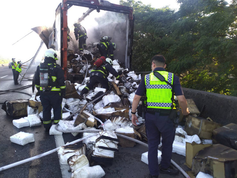 一輛載滿防護隔離衣的大貨車14日上午6時許在國道1號南屯路段突然起火，台中市消防局出動人車前往搶救，車上3人都及時下車避難，雖火勢迅速撲滅，但隔離衣搶救不及全數燒毀。（台中市消防局提供）