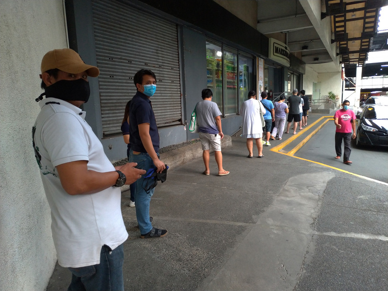 菲律賓武漢肺炎病例數持續攀升，馬尼拉民眾遵照規定保持社交距離。（中央社）