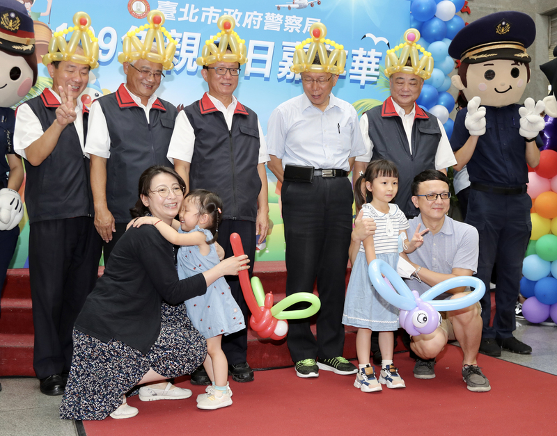台北市長柯文哲（後排左4）21日出席台北市政府警察局109年親子日活動，柯文哲戴著造型氣球皇冠與警眷及小朋友合影。(圖：中央社)