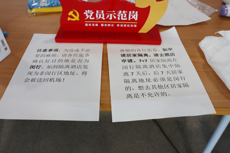 中國上海對入境人員實施有條件的「7天集中＋7天居家」隔離措施，在上海有住所者，會被分派到同區的隔離旅館，方便第二週就近返家隔離。圖為20日上海浦東機場內，閔行區櫃檯的說明。(圖：中央社)
