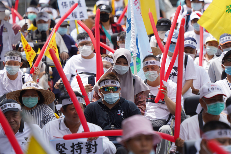 印尼7月底釋出訊息指稱，明年1月起將要求移工輸入國雇主負擔移工來台費用。中華民國脊髓損傷者聯合會27日號召近百名乘著輪椅的身心障礙者赴勞動部抗議，有外籍看護工陪同雇主到場抗議。(圖：中央社)
