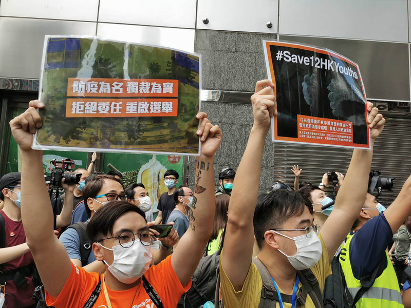 6日香港有民眾在網上發起在九龍佐敦一帶集會遊行，提出反對港區國安法、反對立法會延後選舉等訴求。圖為示威者在佐敦永安百貨外高舉標語。(圖:中央社)