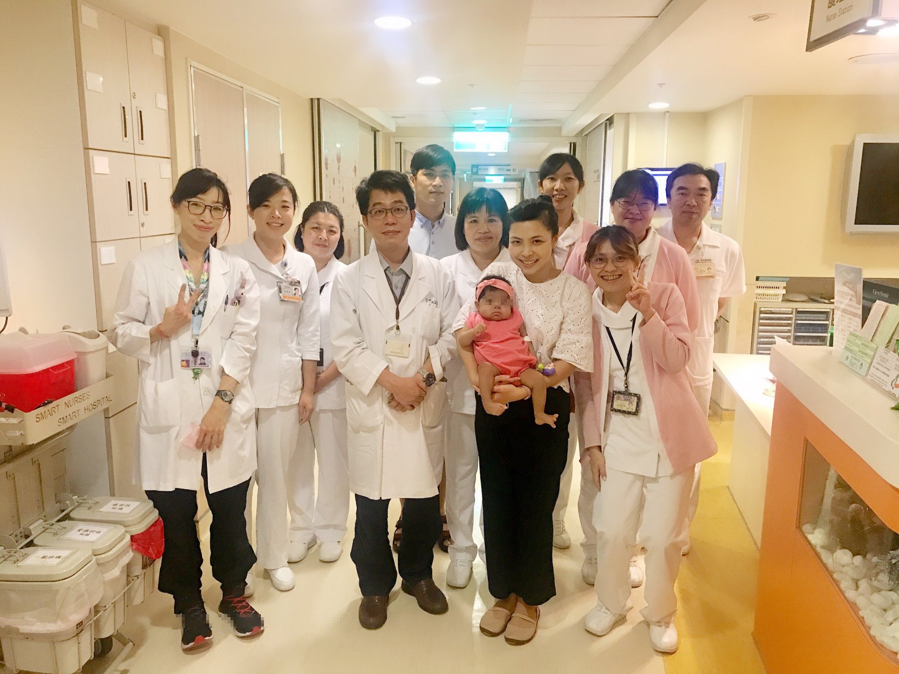 越南黎雲臺妝主播抱著愛女鄧藍葉與移植外科劉君恕主任及醫護人員合影。(北榮提供)