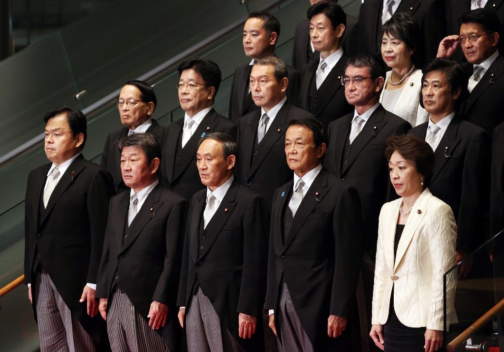 日本新任首相菅義偉(中)和內閣成員合影。(AFP)