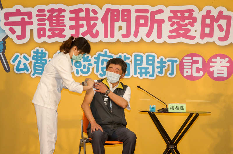 衛福部疾管署5日在台北舉行「守護我們所愛的人」109年公費流感疫苗開打記者會，衛福部長陳時中（右）出席宣傳，現場施打疫苗。 (圖:中央社)