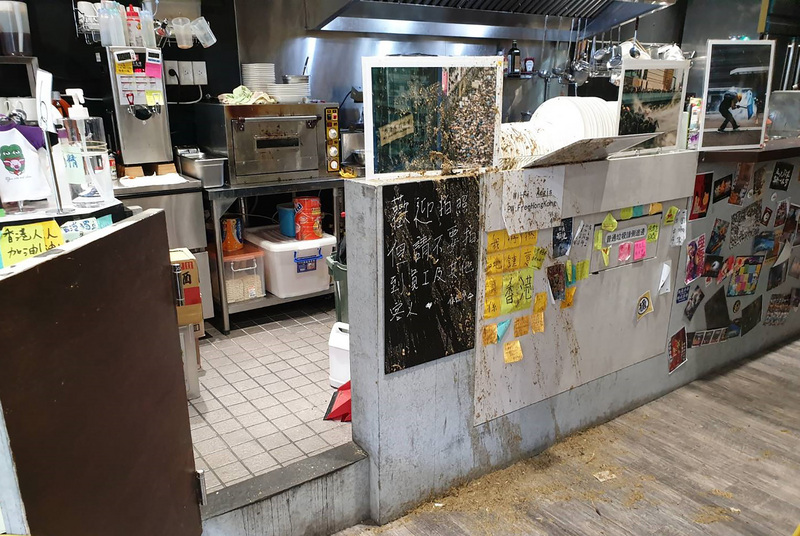 協助在台尋求庇護香港人維持生計的「保護傘」餐廳16日遭人潑穢物，台北市警察局大安分局初步調查，一名黑衣男子中午持裝有雞糞的桶子，徒步前往店家，把雞糞潑灑至櫃檯後，隨即逃離現場。（翻攝照片）