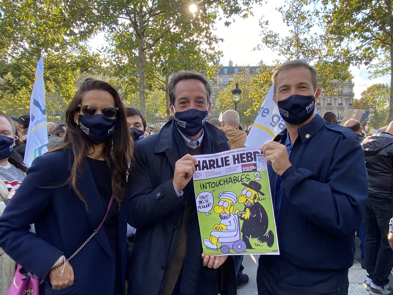法國中間偏左的左翼基進黨主席拉克洛瓦（中）到場聲援遭斬首教師的反恐活動。拉克洛瓦手持查理週刊，強調言論自由的重要性。(圖：中央社)