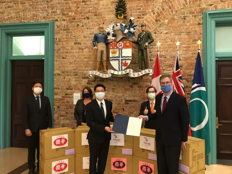 駐加拿大代表陳文儀（前左1）23日拜會渥太華市長華森（Jim Watson，前右1），並代表台商國華台灣食品公司，捐贈2萬片台灣口罩給渥太華市政府。（駐加代表處提供）