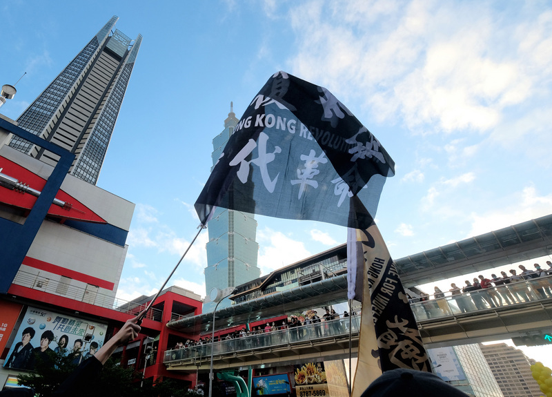 香港反送中運動後，許多港青流亡台灣。圖為「光復香港 時代革命」旗幟在台北信義商圈飄揚。(圖：中央社資料照片)