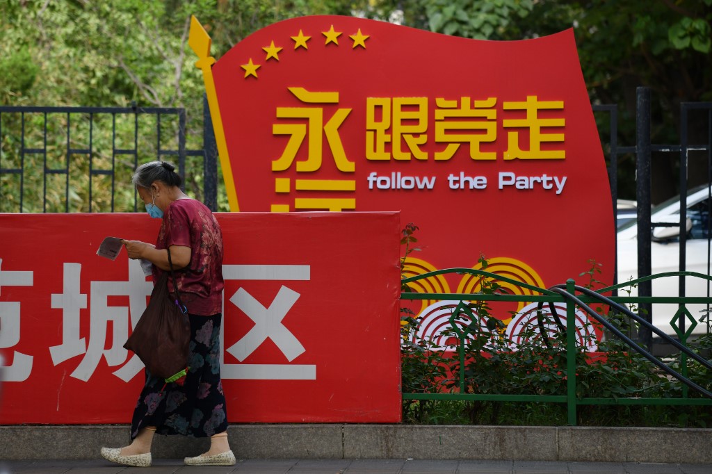 中國力行愛國教育進而著手立法，草案還明確針對港澳及台灣；學者評論立法目的是為壓制對中國不同的政治見解。圖為北京街頭中國共產黨的精神標語「永遠跟黨走」。(AFP)