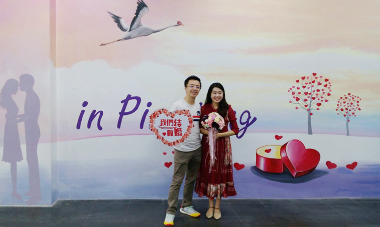 屏東市戶政事務所彩繪結婚打卡牆，並提供捧花及不同手拿板拍照留念，讓新人在登記結婚時有滿滿的幸福感。（屏東市戶政事務所提供）