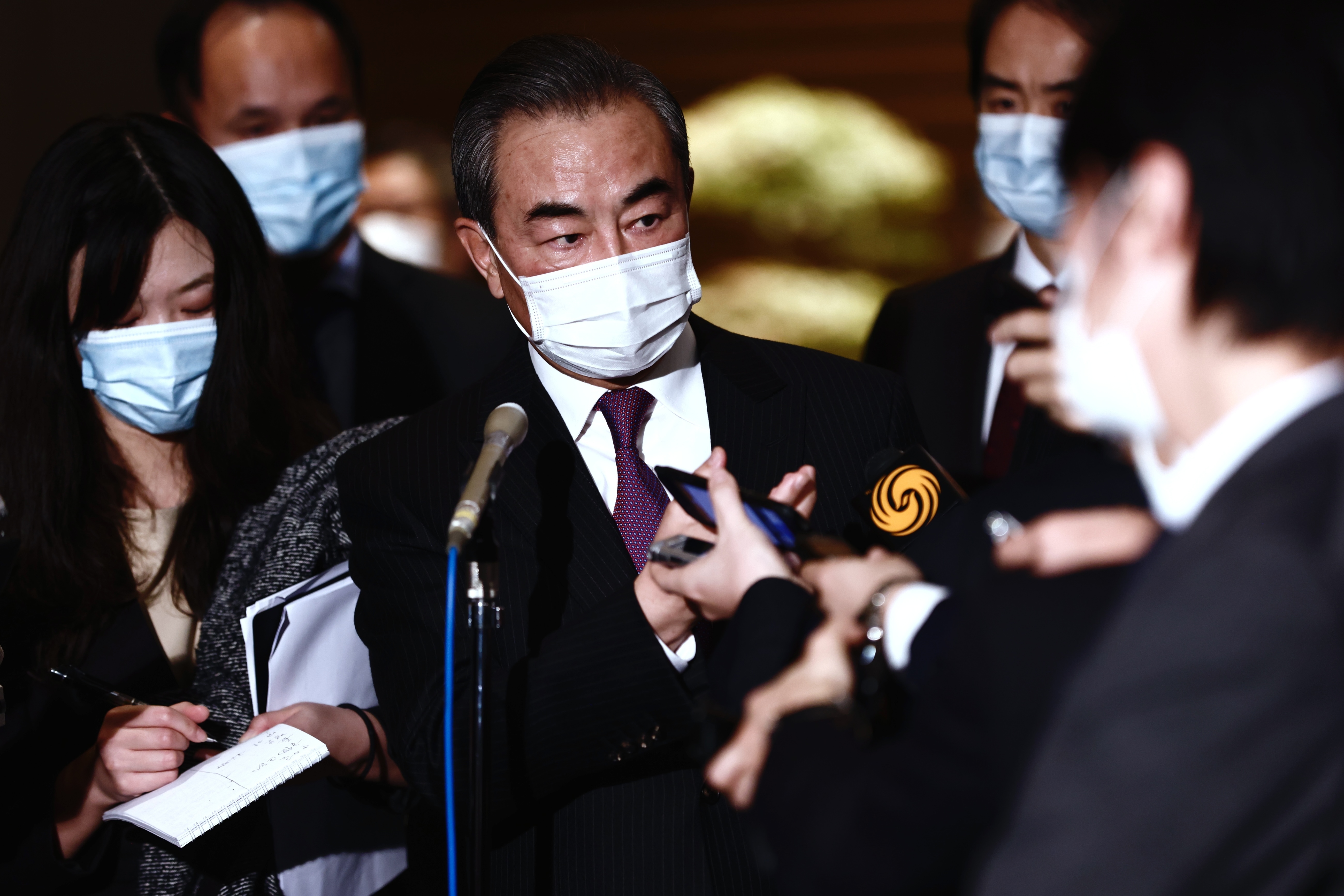 中國外長王毅(中)25日在東京會見日本首相菅義偉後，接受媒體採訪。(美聯社/達志影像)