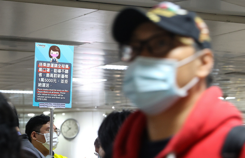秋冬防疫專案1日啟動，台北捷運工作人員在出入口舉牌，提醒民眾搭乘捷運應全程戴口罩，未依規定戴口罩且勸導不聽者，可依法裁罰。(圖:中央社)