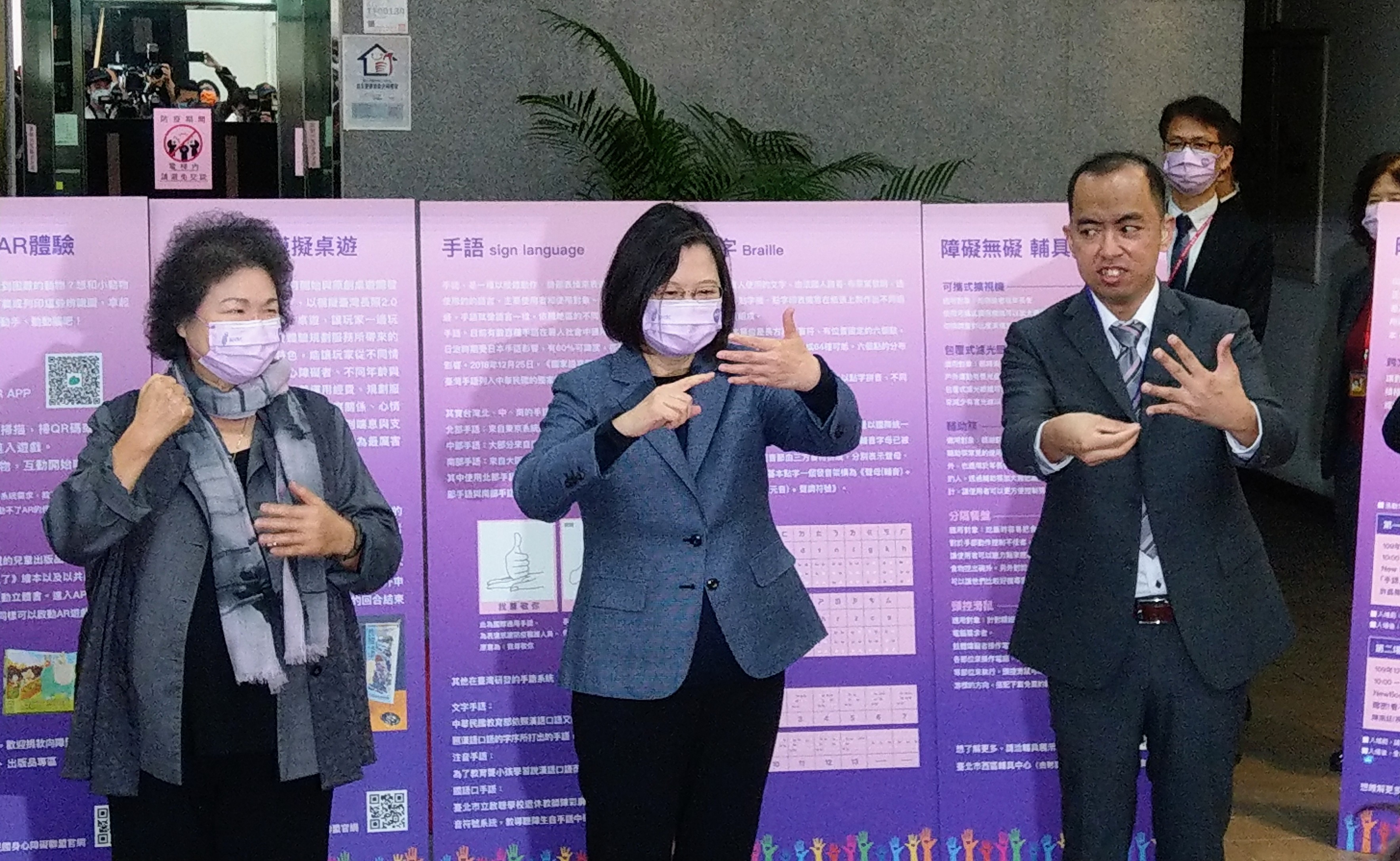 蔡英文總統(中)、國家人權委員會主委陳菊(左)一同觀看「人權主題特展」，並現場學習「台灣人權升級」的手語。(歐陽夢萍 攝)