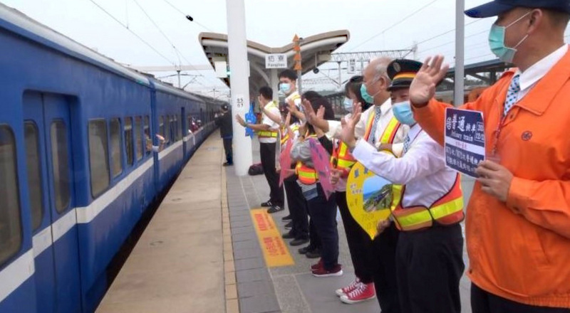 全台僅存的藍皮普快列車23日起停駛，22日最後一班列車吸引許多民眾搭乘。當列車駛出車站，台鐵人員在月台列隊，向藍皮火車揮手道別。(圖：中央社)