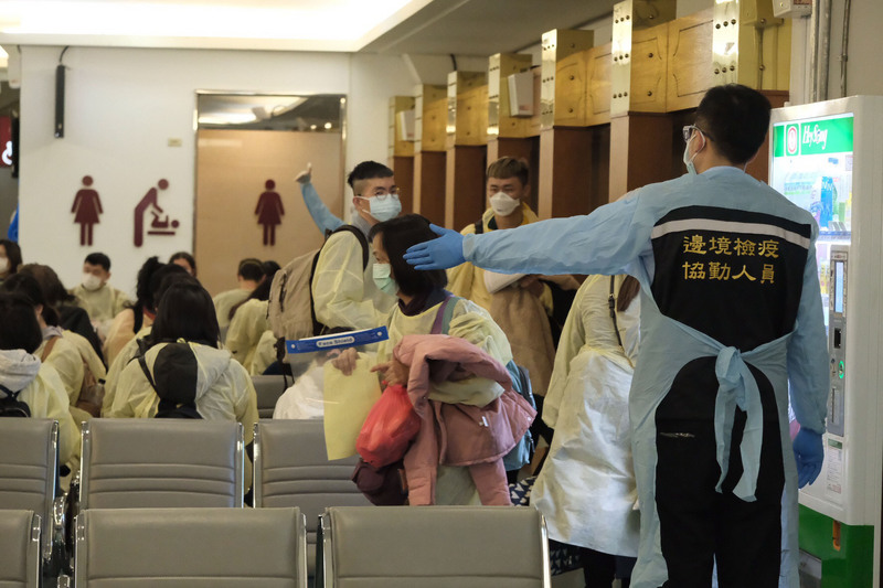 從英國載送114名旅客的華航班機27日下午5時餘抵達桃園機場，機場檢疫人員嚴陣以待，旅客走獨立通道，與其他航班的旅客分流。(圖：中央社)
