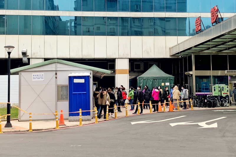 衛生福利部桃園醫院戶外採檢區24日上午陸續有人排隊等候採檢，人員都緊戴口罩，依序排隊等候，到了下午4時許出現較多人潮，但對於疫情採檢等相關問題都不願多談。 (圖：中央社 )