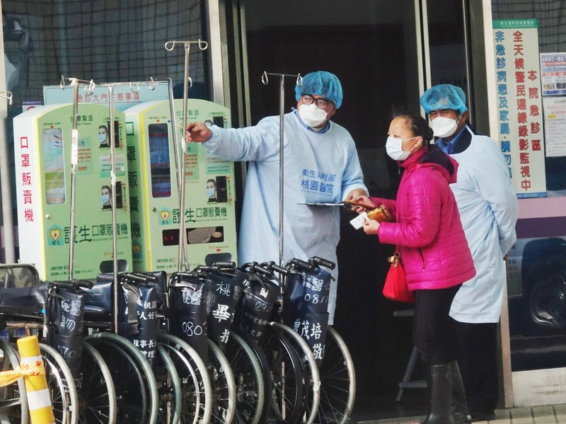 衛生福利部桃園醫院發生武漢肺炎群聚感染，部桃醫護人員25日在出入口外嚴陣以待，不敢有絲毫懈怠。 (圖：中央社)