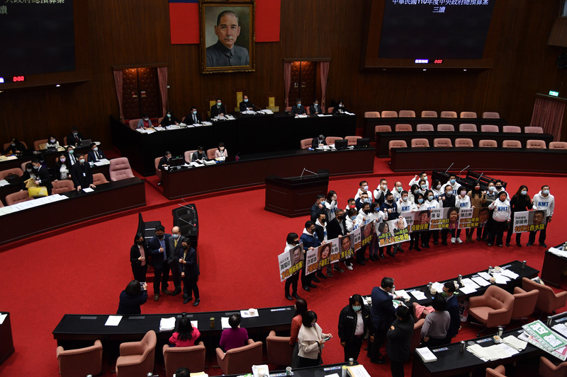 立法院臨時會29日上演表決大戰，力拚三讀。臨時會結束後，國民黨籍立委在場內齊聚舉牌，表達對部分法案的不滿。圖左側為民進黨立委開心合影比讚。 (圖：中央社)