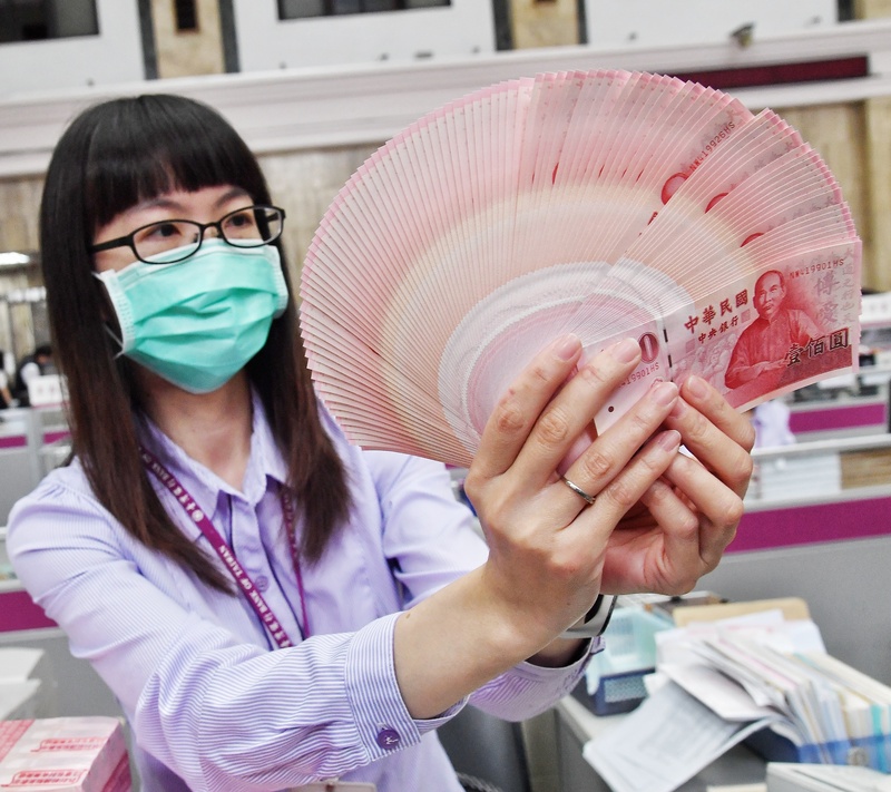今年稅收「超徵」，多位民意代表呼籲發現金給民眾。圖為農曆春節前台灣銀行開放民眾換新鈔，行員清點鈔票。 (圖：中央社資料照片)