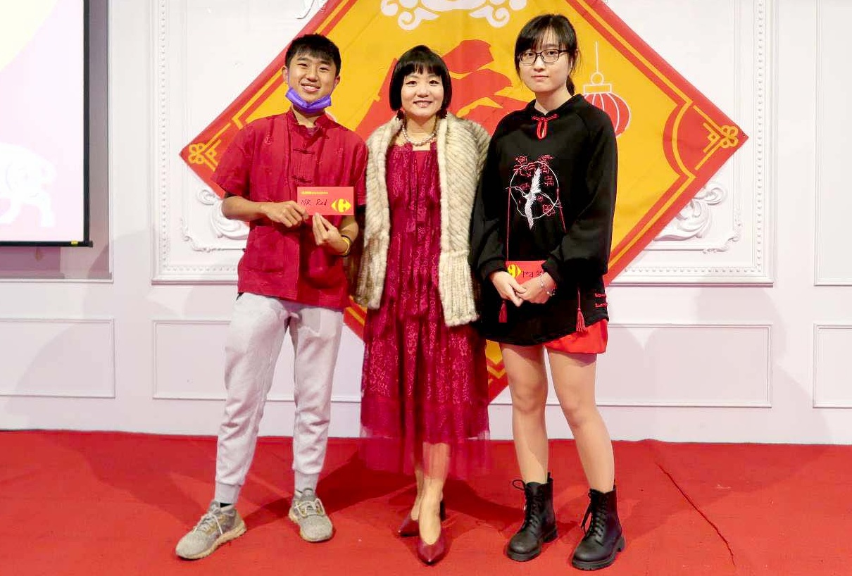 一身火紅的屏東科技大學副國際長簡赫琳(中)，頒獎給「紅色先生」得主余偉盛(左)與「紅色小姐」得主陳雪妮(右)。(屏科大提供)
