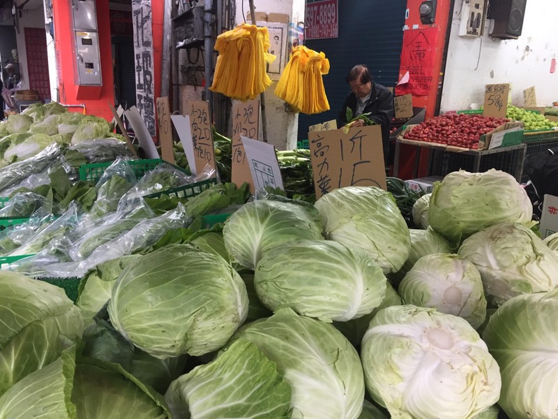 春節過後17日開工首日，高麗菜在台北果菜批發市場的交易均價每公斤已跌到新台幣6.2元，快要破6元。攤商整理賣相好拉提售價。 (圖：中央社)