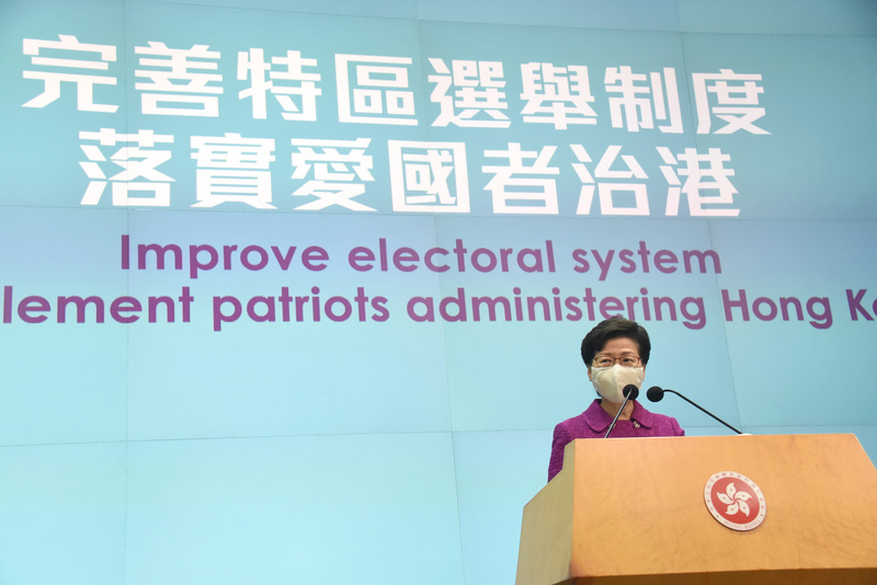 北京近期多番強調「愛國者治港」，確保管治權牢牢掌握在「愛國者」手中。圖為香港特首林鄭月娥8日舉行記者會時，身後打出相關標語。（中新社提供） (圖：中央社)