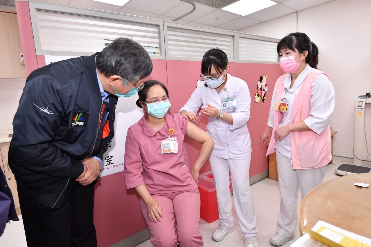 台北市長柯文哲(左一)22日赴和平醫院視察COVID-19疫苗施打情況。圖為負壓隔離病房護理長李金霙施打疫苗。(北市府提供)