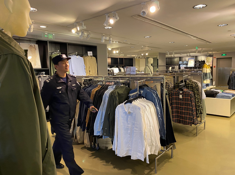 歐洲服飾品牌H&M正因禁用新疆棉而遭到中國輿論抵制。一名員警25日來到上海黃浦區一家H&M門市，他詢問店員這兩天的生意，店員指著店內為數不多的顧客說：「唉，你也看到了。」 (圖：中央社)