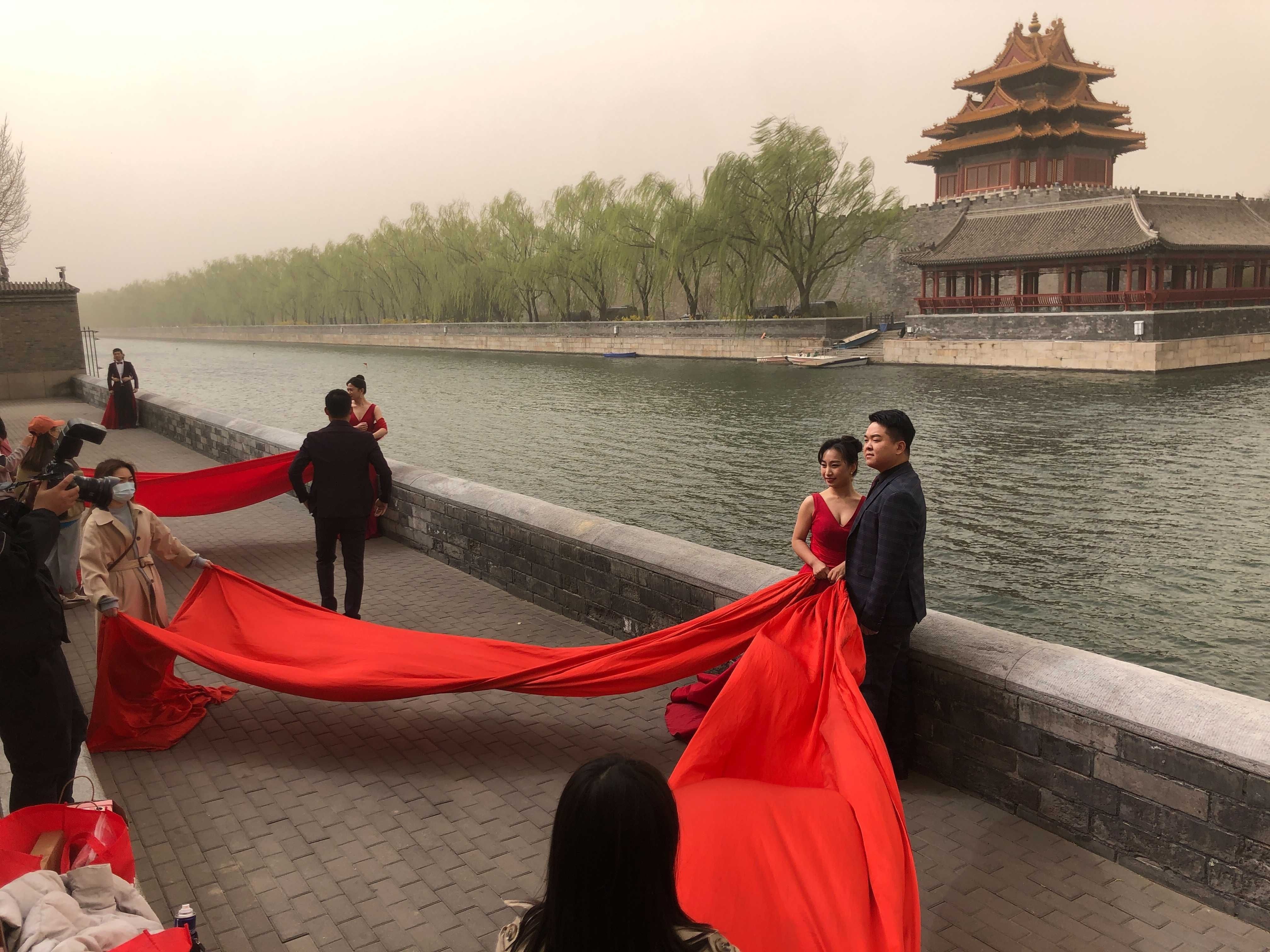 圖為北京一對新人28日在沙塵暴的天氣中，在紫禁城附近拍照。(美聯社/達志影像)
