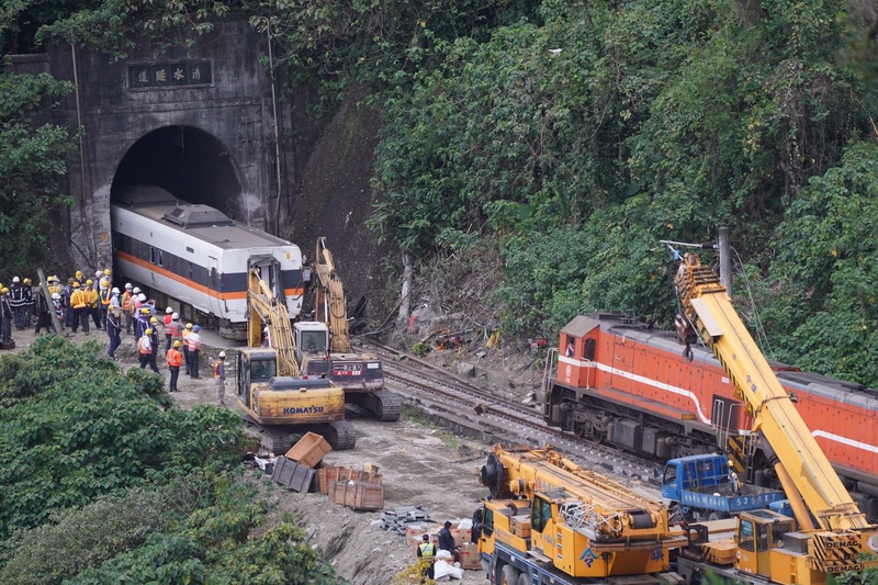 台鐵太魯閣號2日發生出軌事故，工程人員動用柴油火車頭與怪手將毀損車廂拉出隧道。 (圖：中央社)
