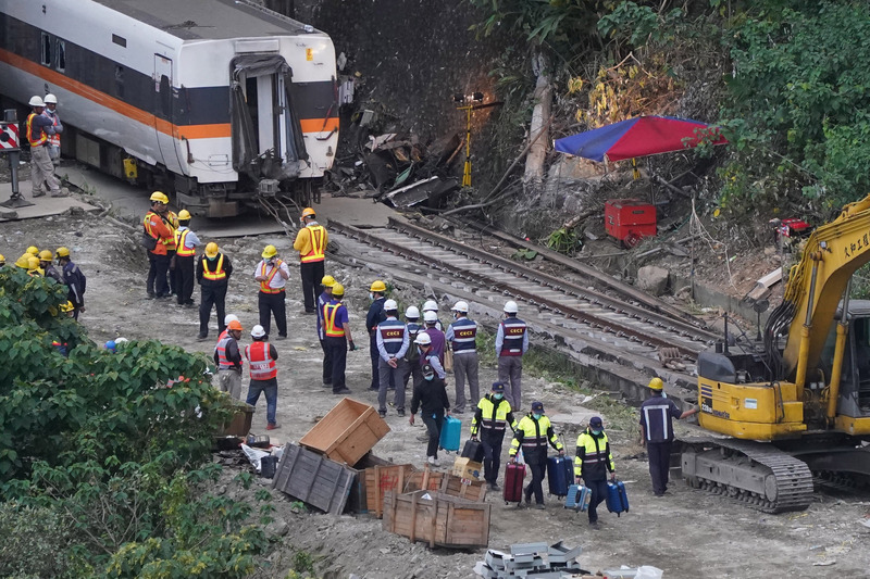 台鐵太魯閣號事故現場4日持續進行搶通，員警們午後陸續從車廂內攜出旅客行李。 (圖：中央社)