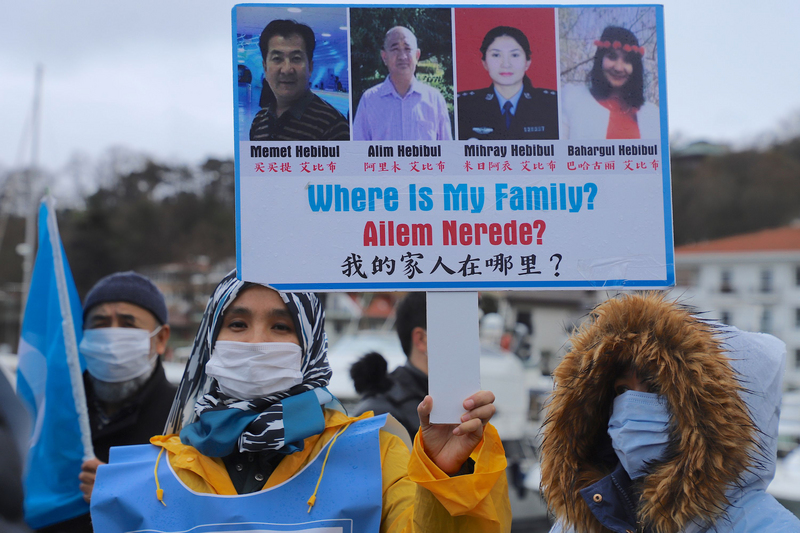 「集中營受難者家屬平台」5日在中國駐伊斯坦堡總領事館外示威，一名婦女高舉寫有「我的家人在哪裡？」海報，控訴中共暴行。 (圖：中央社)