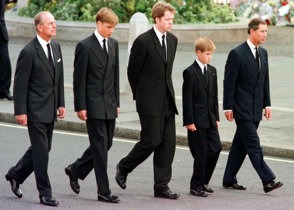 1997年黛安娜王妃(Princess Diana)出殯時，菲立普親王陪著年幼的孫子─15歲的威廉和12歲的哈利走在西敏寺(Westminster Abbey)外送別黛妃。(AFP)