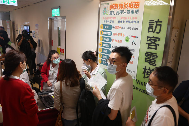 牛津AZ疫苗21日起開放自費接種，亞東醫院上午開始出現排隊等候接種疫苗的人潮。 (圖：中央社)