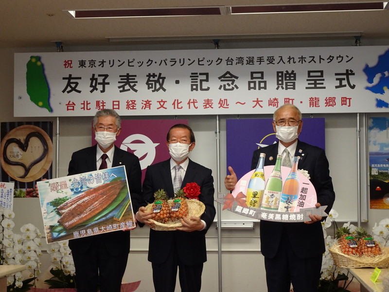 駐日代表謝長廷（中）26日造訪鹿兒島縣，贈送台灣金鑽鳳梨給登記東京奧運台灣選手接待城市的該縣大崎町與龍鄉町。 (圖：中央社)