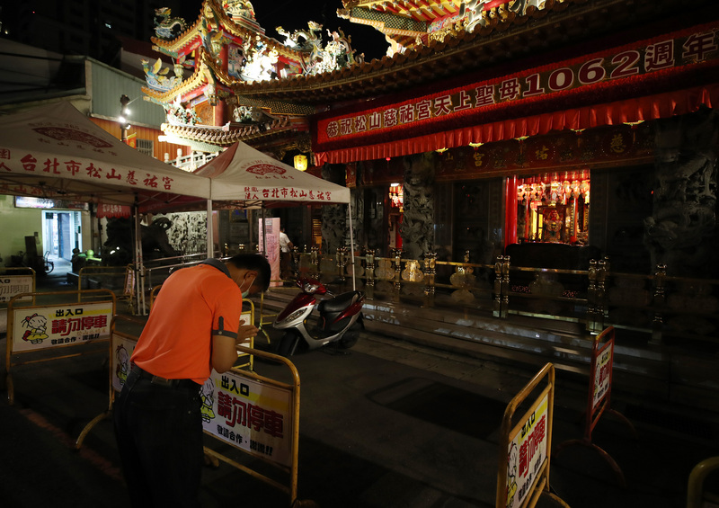 本土疫情升溫，內政部次長陳宗彥15日表示，即日起，全國各地宗教寺廟暫不開放入內參拜至6月8日。財團法人台北市松山慈祐宮晚間關起廟門，民眾改在廟門外雙手合十祭拜。 (圖：中央社)