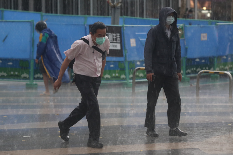 中央氣象局24日下午發布豪雨特報，受鋒面接近及午後對流雲系發展旺盛影響，新北市、台北市有局部大雨或豪雨發生。圖為台北街頭民眾急忙快步避雨。 (圖：中央社)